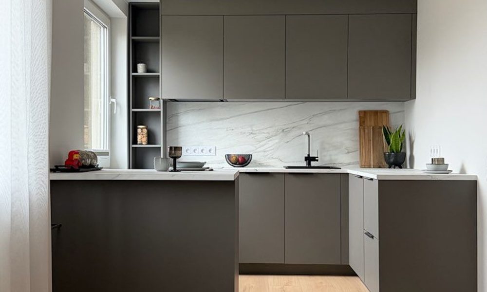 Modernne väike köök mustade käepidemete ja heleda marmori efektiga tasapinnaga